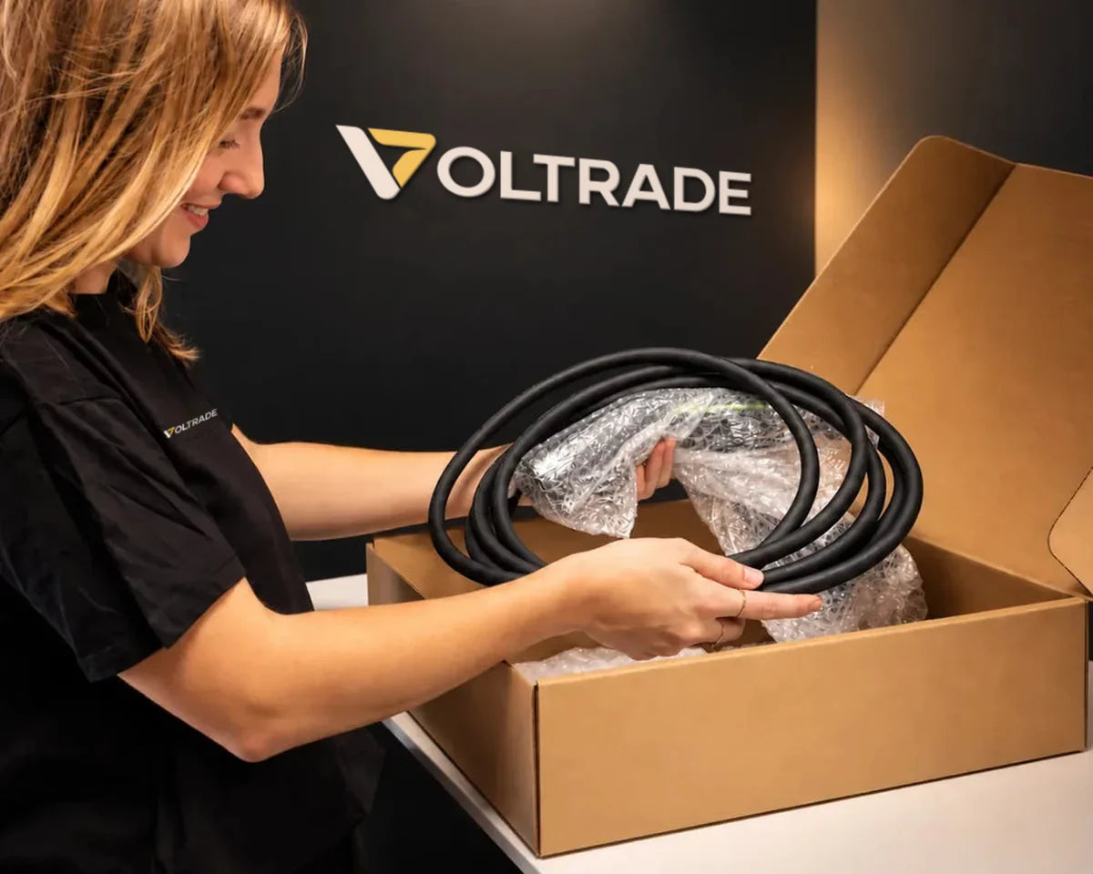 Medewerker van Voltrade haalt een laadkabel uit de verzenddoos